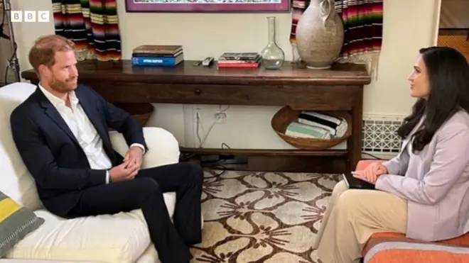 Duke of Sussex sat in a suit sat on a sofa opposite Nada Tawfik