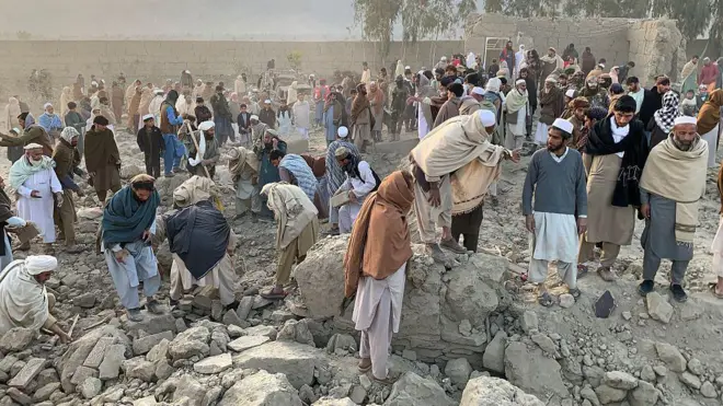 Afghan men search for victims after an overnight Pakistani air strike hit a residential area in the Girdi Kas village of Bihsud district, Nangarhar province on February 22, 2026.