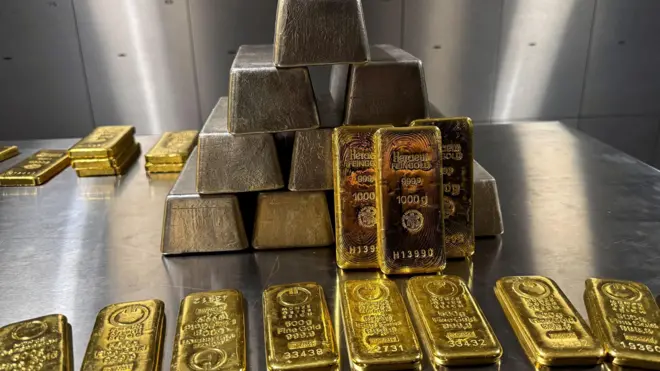 златне полуге наређане на сивом столу