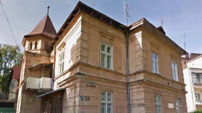 Будинок з двома поверхами, коричневі стіни, добудований зліва балкон