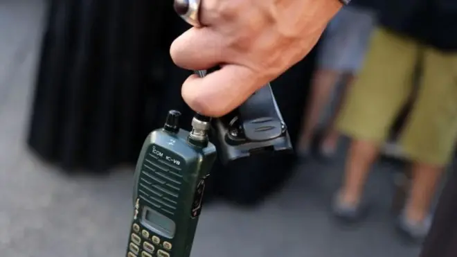 رجل يحمل جهاز اتصال لاسلكي في بيروت يبدو أنه من تصنيع آيكوم 