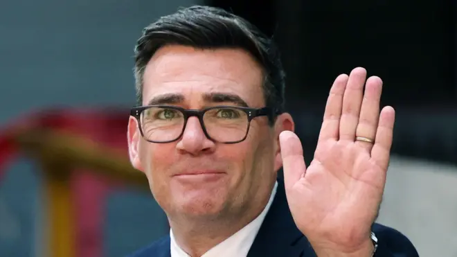 17 Temmuz'da İşçi Partisi'nin yeni lideri ilan edilen Andy Burnham bir elini kaldırmış ve kameraya bakara selamlıyor