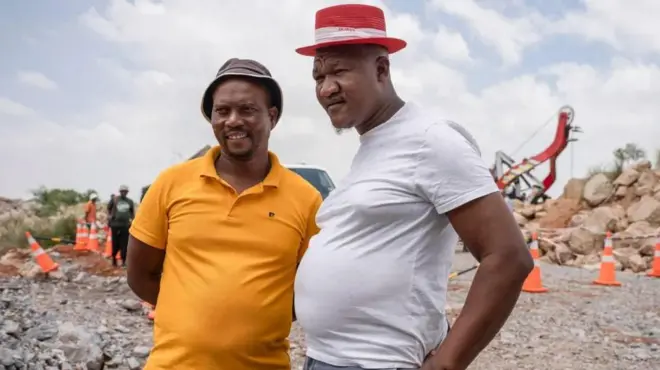 Wafanyakazi wa kujitolea Mzwandile Mkwayi (kulia) na Mandla Charles (kushoto) walilakiwa kama mashujaa baada ya kushuka kwenye shimo la kuchimba madini.