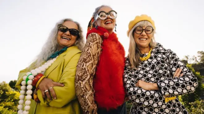 Femmes âgées élégantes souriant joyeusement dans un parc.