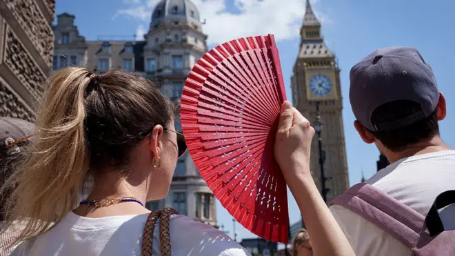 Mujer se abanica mientras de fondo está el Big Ben