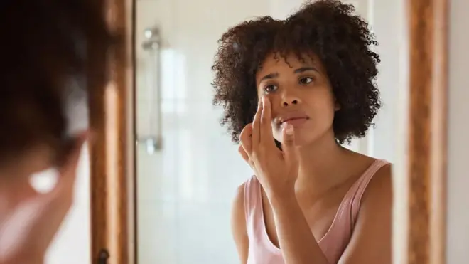 سيدة تضع مستحضرات للعناية بالبشرة.