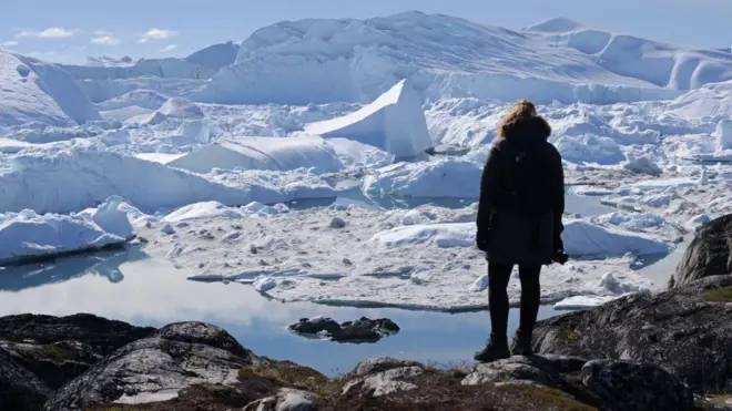 Una mujer contempla un paisaje helado en Groenlandia.