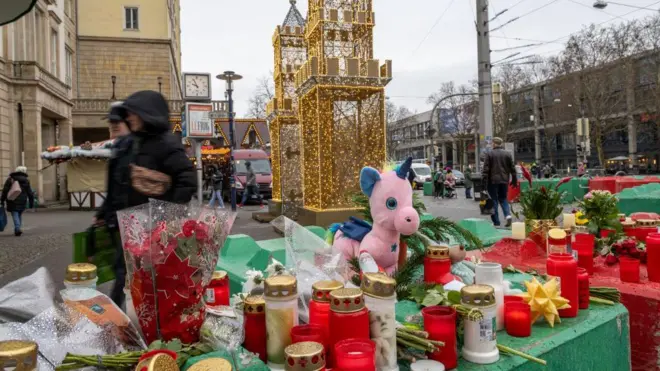 Magdeburg'da saldırı yerinde anma için oluşturulan köşede çiçekler, mumlar ve bir oyuncak