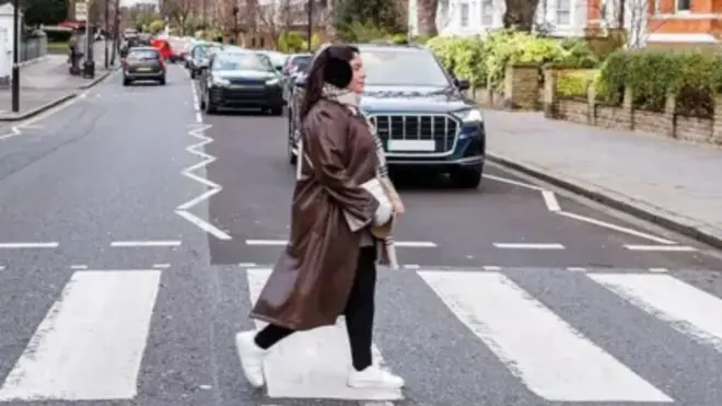 Una mujer cruzando Abbey Road, en Londres
