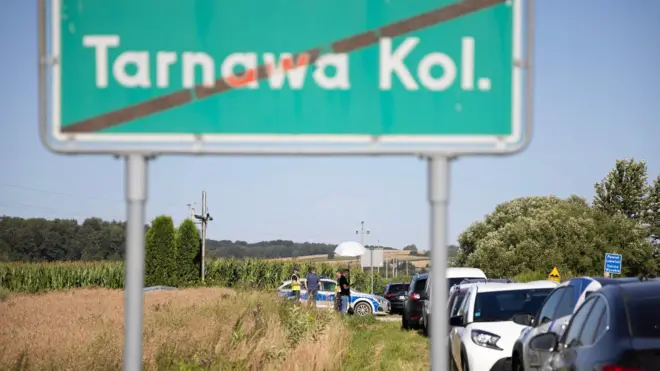 Znak drogowy z napisem „Tarnawa Kolonia” i samochody widoczne w pobliżu miejsca, gdzie po naruszeniu polskiej przestrzeni powietrznej spadł obiekt uznawany za rosyjski pocisk manewrujący. ZAKAZ DYSTRYBUCJI W POLSCE.