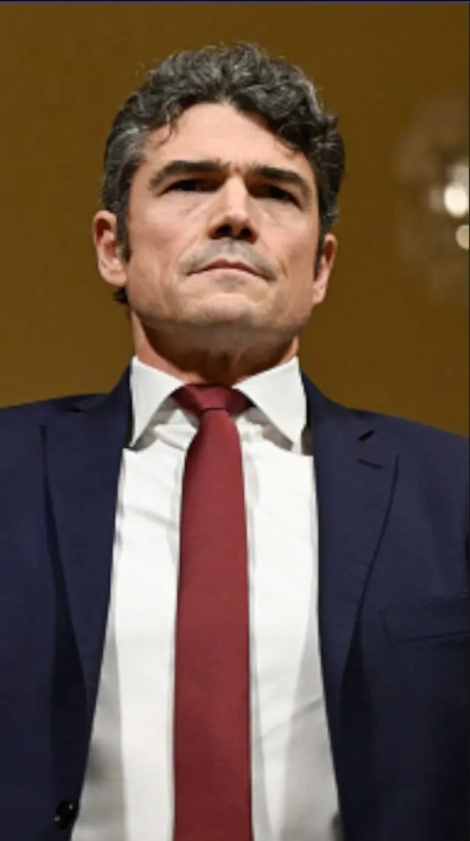 ඇමෙරිකානු ජාතික ත්‍රස්ත විරෝධී මධ්‍යස්ථානයේ අධ්‍යක්ෂ ජෝ කෙන්ට් කළු කෝට් එකක් ඇඳ රතු-දුඹුරු පැහැති ටයි පටියක් පැළඳ සිටි.