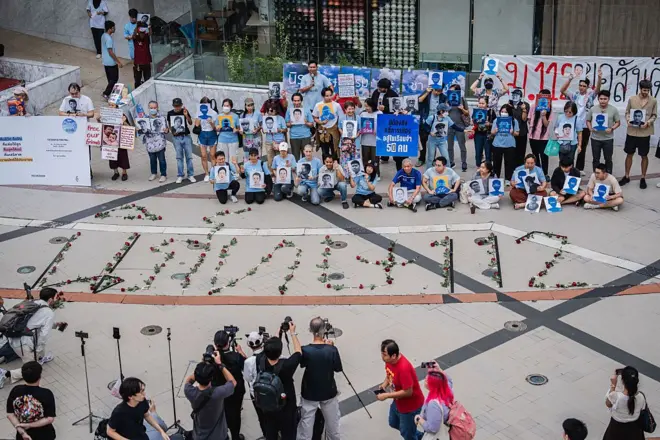 Protesters pose with portraits of activists during a vigil
BANGKOK, THAILAND - 2025/07/15: Protesters pose with portraits of activists during a vigil with red roses on the ground spelling out "Repeal 112," referencing Section 112 of the Thai Criminal Code. People gathered outside Bangkok Art and Culture Centre for a candlelight vigil titled "Light Up Hope for the People's Amnesty." Organized ahead of a parliamentary debate on the 16 July 2025, the event featured personal testimonies, portraits of 50 political detainees, and a red rose display reading "Amnesty 112." Participants called for the passage of a comprehensive amnesty bill covering cases under Section 112 of the Thai Criminal Code. (Photo by Ploy Phutpheng/SOPA Images/LightRocket via Getty Images)