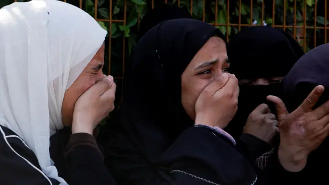 فلسطينيات في خان يونس يبكين المسعفين الذين تعرضوا لإطلاق نار إسرائيلي أثناء مهمة إنقاذ في جنوب قطاع غزة