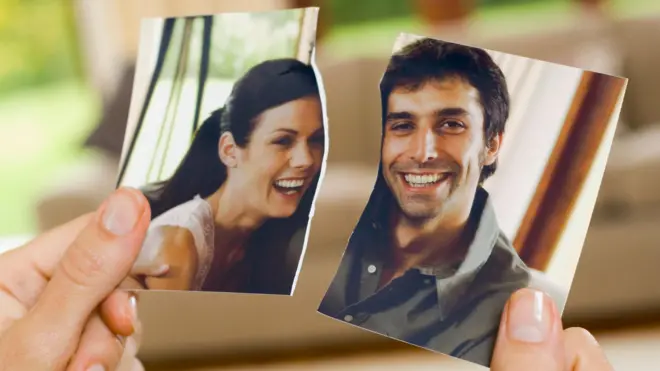 Руки з порваною фотографією пари - стокове фото