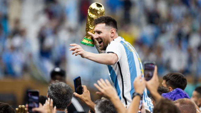 Lionel Messi celebrates with the 2022 World Cup trophy