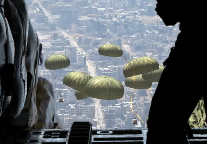 أفراد من القوات المسلحة الأردنية يسقطون طرود مساعدات جواً فوق غزة، 9 أبريل 2024.