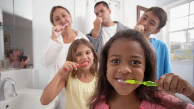 Una familia de cinco cepillándose los dientes