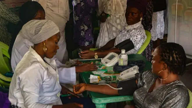 Medical personnel attend to a woman during a free medical screening in commemoration of the International Day for Women at the Mobolaji Johnson Arena in Lagos, Nigeria.