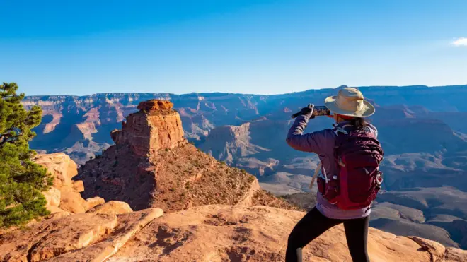 Mulhervbet zangcostas tirando foto no Grand Canyon