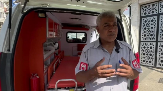 Mahmoud gesticula enquanto faladias de sorteio das loterias da caixafrente a ambulância