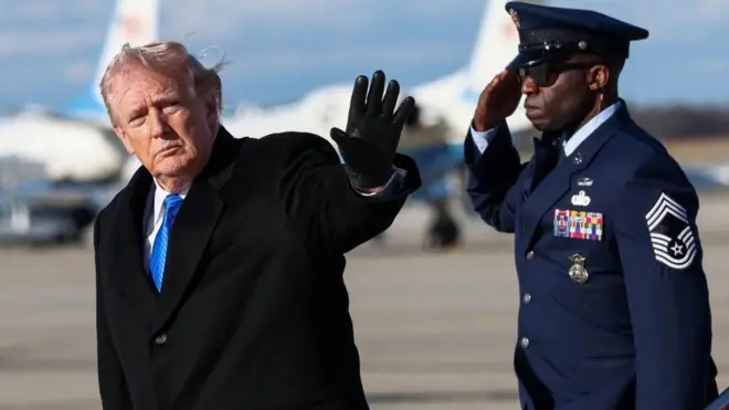 Trump waves as a military serviceman salutes