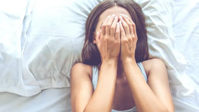 Young woman in bed trying to sleep