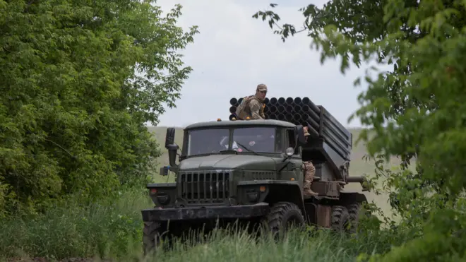 جنود أوكرانيون يركبون شاحنة تحمل نظام صاروخ الإطلاق المتعدد BM-21 Grad بالقرب من خط أمامي في منطقة دونيتسك في 21 يونيو-حزيران