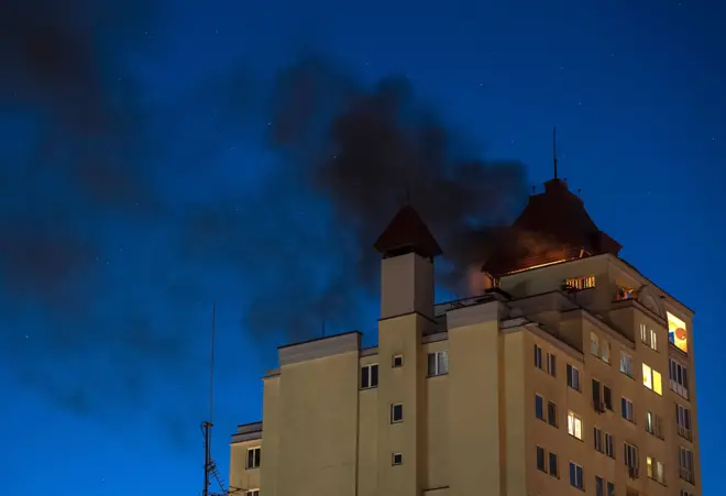 Дим здіймається після того, як уламки перехопленого російського дрона впали на дах багатоповерхового житлового будинку в Києві, Україна, 12 травня 2026 року.