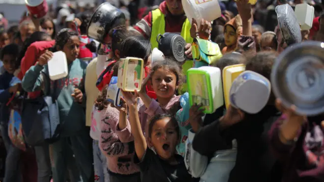 منظمات توزع وجبات ساخنة على الفلسطينيين في مخيم النصيرات للاجئين في قطاع غزة الذين يعانون من الجوع