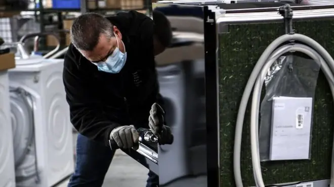 Рабочий осматривает стиральную машину