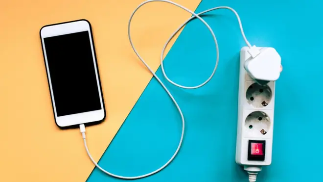 Un téléphone branché sur une source électrique