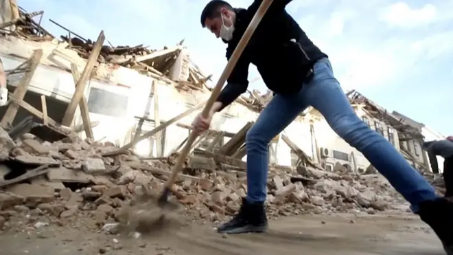 Čovek kopa ko ruševinama