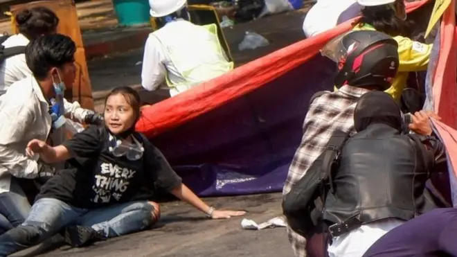 Protesters lie on the ground in Myanmar after troops opened fire