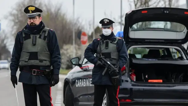 Italian checkpoint, guard in mask with gun