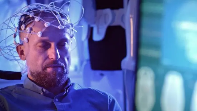 Muškarac sedi dok su mu na glavi uređaji za merenje moždane aktivnosti