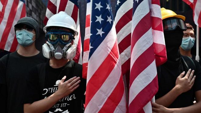 Protesters sing the Star-Spangled Banner as they march while holding the US flag at the Hong Kong University (HKU) campus on September 20, 2019,