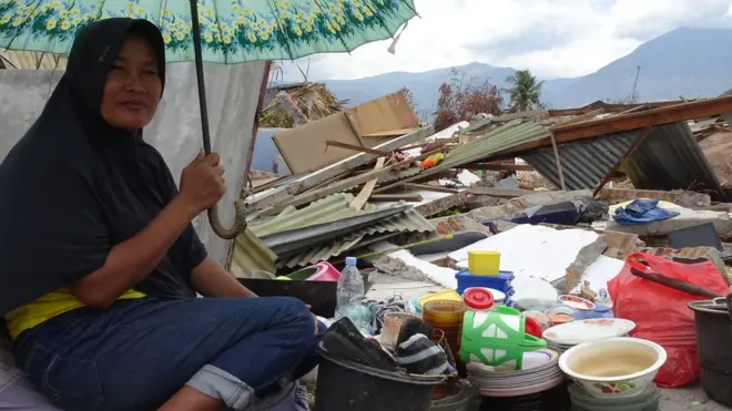 Hasnah mengumpulkan barang-barang yang masih bisa diselamatkan dari bekas rumahnya di Petobo, Palu.