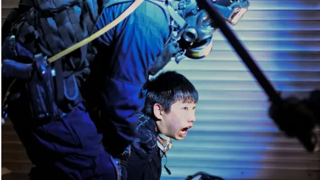 Polisi Hong Kong menahan seorang demonstran di luar kantor polisi Tsim Sha Tsui, pada 11 Agustus lalu.