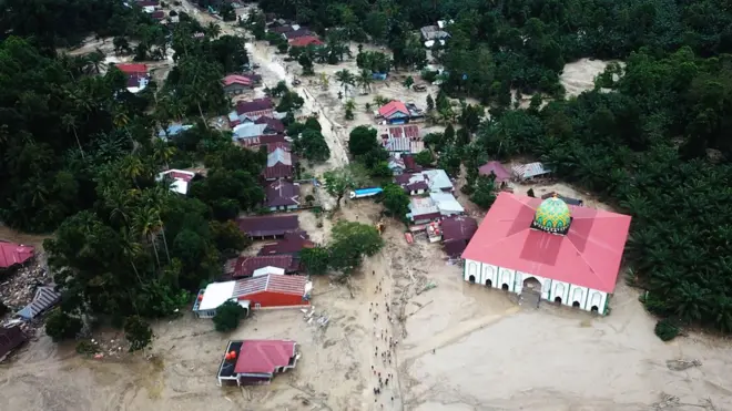 Foto udara kondisi perkampungan tertimbun lumpur akibat terjangan banjir bandang di Desa Radda, Kabupaten Luwu Utara, Sulawesi Selatan, Rabu (15/07).