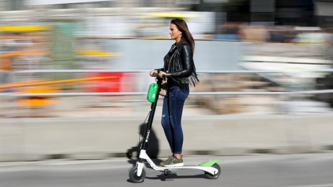 A woman rides a Lime scooter in Madrid