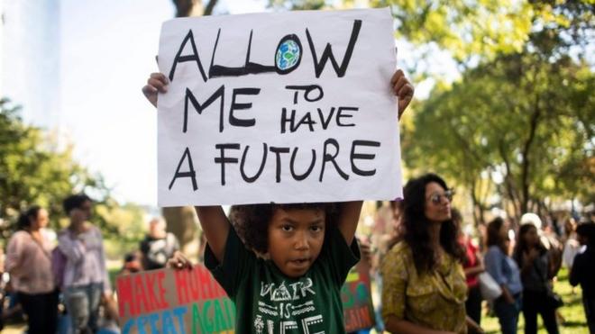 A child holds up a sign reading, "Allow me to have a future" at a climate rally in New York - one of many taking place worldwide on 20 September 2019