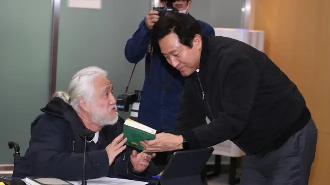 박경석 전국장애인차별철폐연대 상임공동대표가 2일 서울 중구 서울시청에서 열린 간담회에서 오세훈 서울시장에게 자료를 전달하고 있다