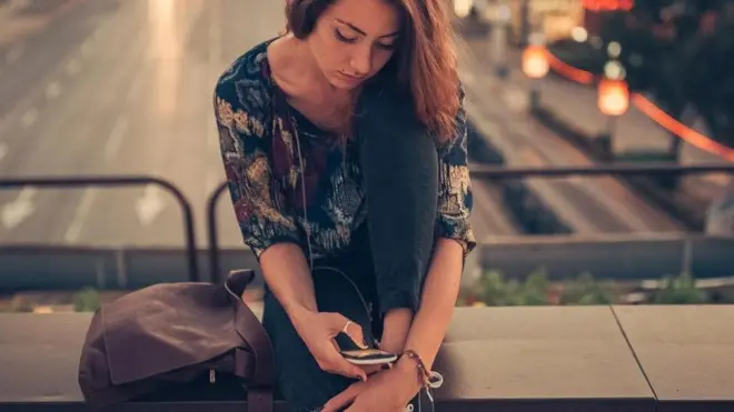 فتاة تتصفح هاتفها المحمول