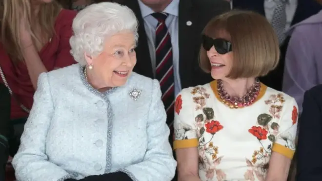 สมเด็จพระราชินีนาถเอลิซาเบธที่สอง ประทับเคียงข้างนางแอนนา วินทัวร์ บรรณาธิการบริหารนิตยสารโว้ก