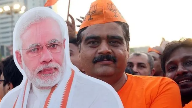 रामलीला मैदान में नरेंद्र मोदी की चुनावी रैली में कटआउट के साथ बीजेपी सपोर्टर.