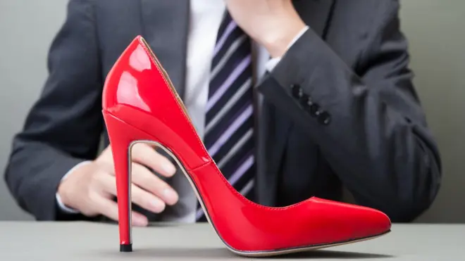 Мужчина смотрит на туфлю на высоком каблуке