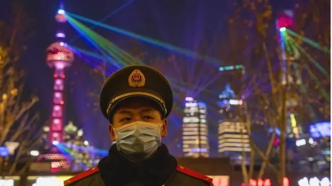 A member of the PLA guards regulates pedestrians on The Bund waterfront area during New Year"s Eve celebrations in Shanghai, China, 31 December 2020
