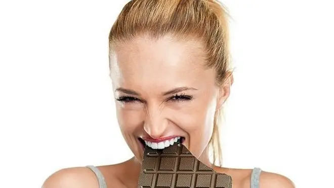 امرأة تتناول الشوكولاته بسعادة