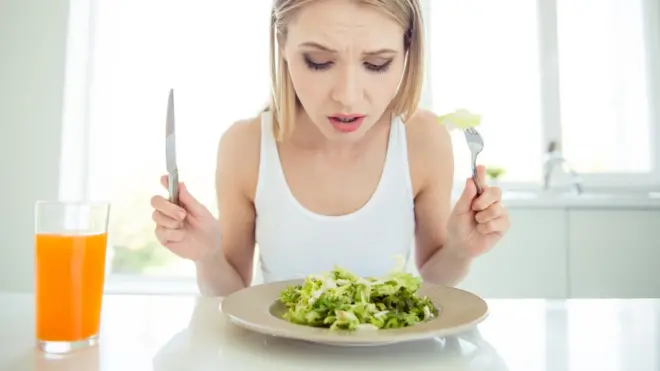 Mujer frente a un plato de comida