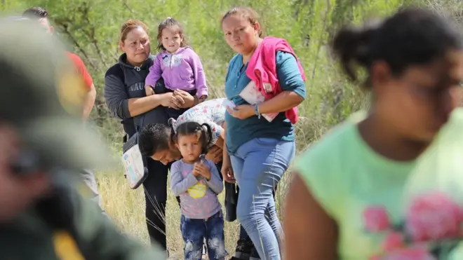 Central American asylum seekers wait as US Border Patrol agents take them into custody near McAllen, Texas.